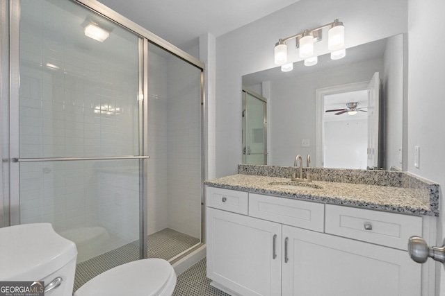 bathroom featuring ceiling fan, a shower stall, toilet, and vanity