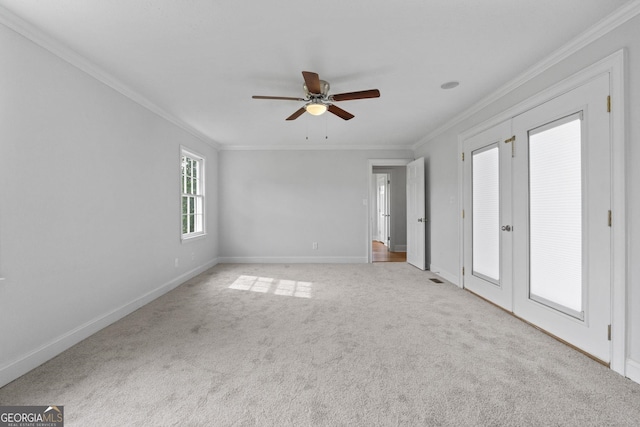 interior space featuring ornamental molding, light carpet, baseboards, and a ceiling fan