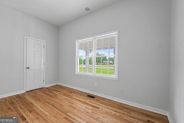 spare room with visible vents, light wood-style flooring, and baseboards