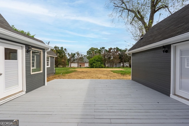 wooden terrace featuring a lawn