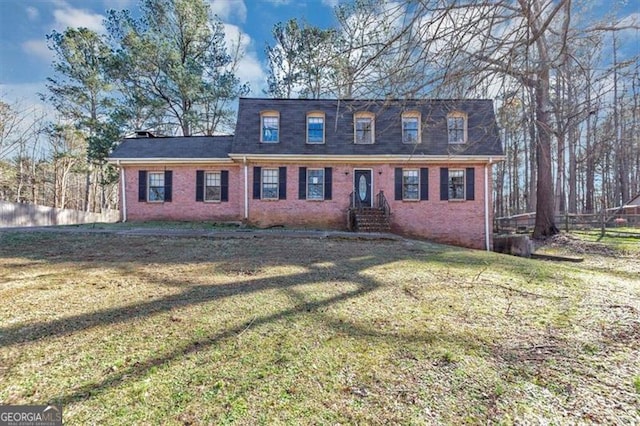 cape cod home with fence, a front lawn, and brick siding