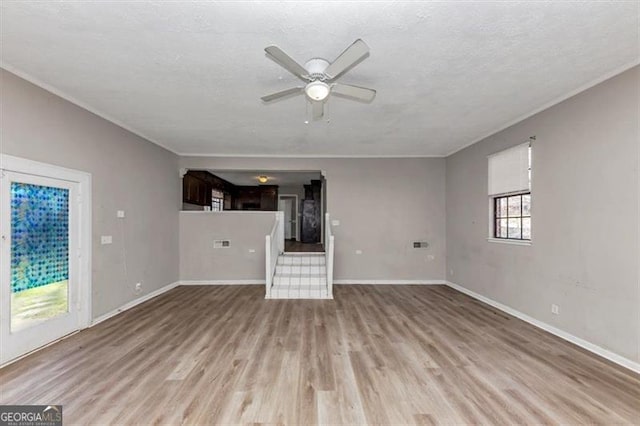 unfurnished living room featuring ceiling fan, a textured ceiling, baseboards, and wood finished floors