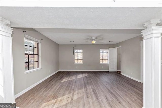 spare room with a ceiling fan, a textured ceiling, baseboards, and wood finished floors