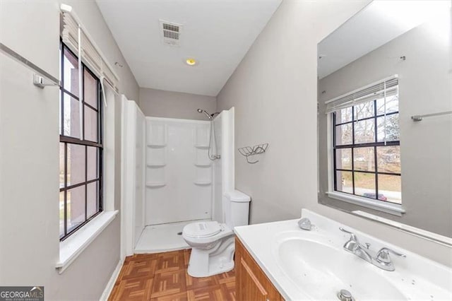 bathroom featuring a shower, visible vents, vanity, and toilet