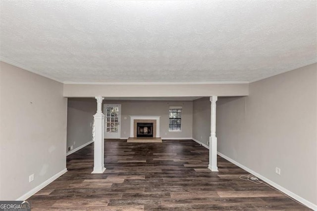 basement featuring a fireplace with raised hearth, a textured ceiling, wood finished floors, and baseboards