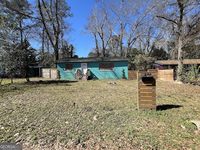 view of front facade with a front yard and concrete block siding