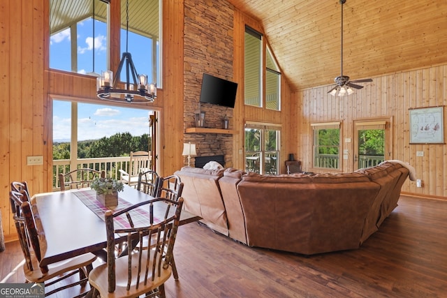 living area with a healthy amount of sunlight, wooden walls, and wood finished floors