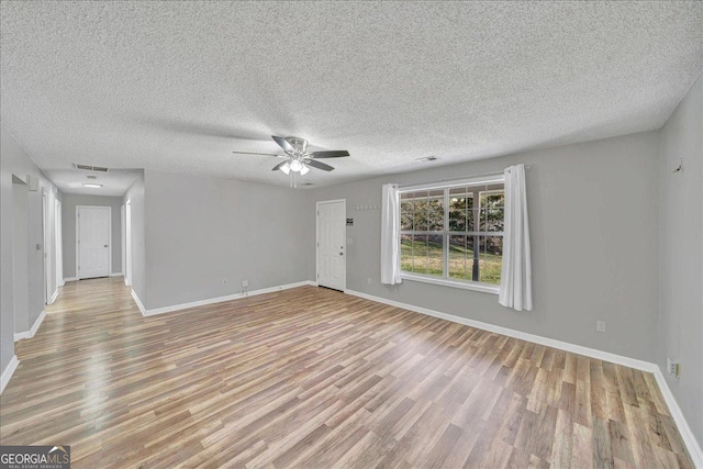 unfurnished living room featuring ceiling fan, light wood-type flooring, visible vents, and baseboards