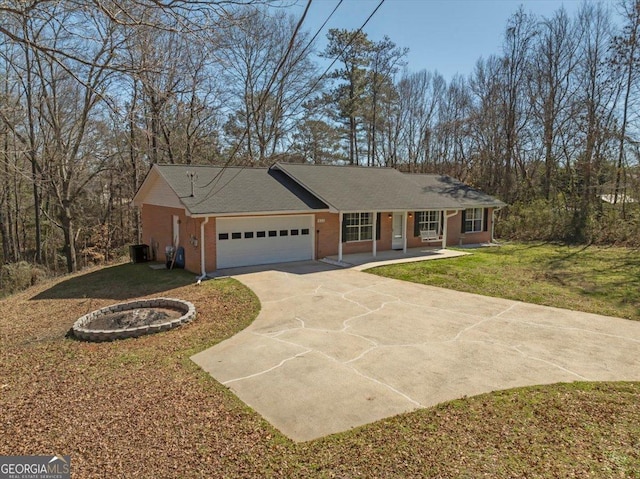 single story home with an attached garage, covered porch, brick siding, driveway, and a front yard