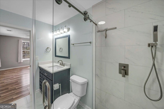 bathroom with toilet, baseboards, wood finished floors, and vanity