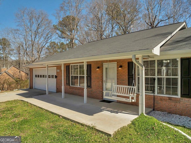 single story home with brick siding, roof with shingles, a porch, an attached garage, and driveway