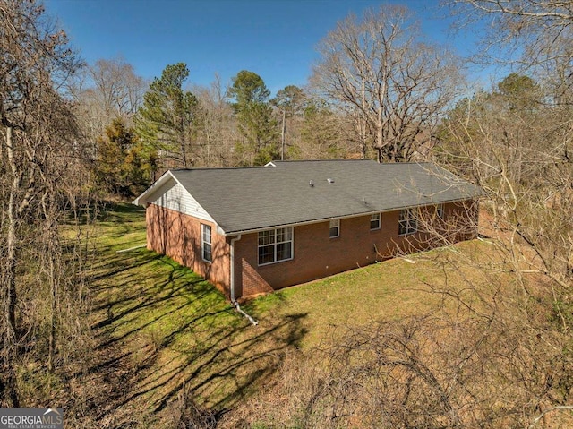 exterior space featuring a lawn and brick siding