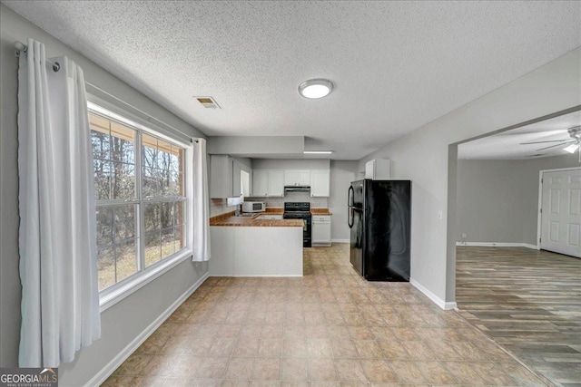 kitchen featuring visible vents, white cabinets, open floor plan, a peninsula, and black appliances