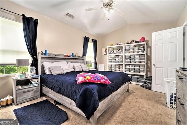 bedroom with a ceiling fan, light colored carpet, visible vents, and vaulted ceiling