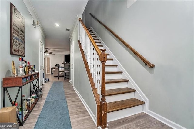 stairway with a ceiling fan, wood finished floors, visible vents, and baseboards