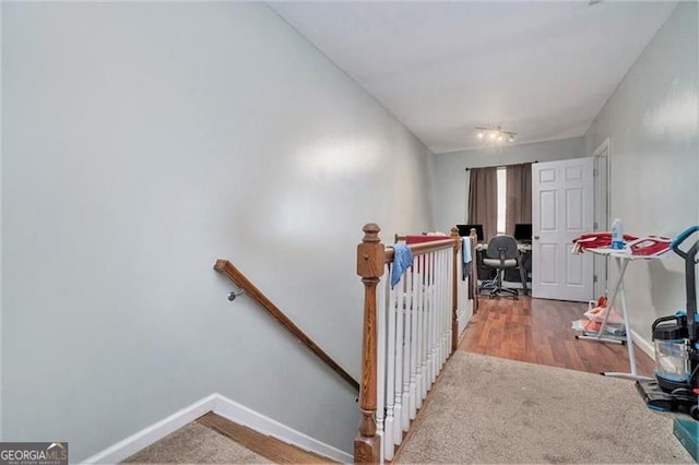 stairs with wood finished floors and baseboards