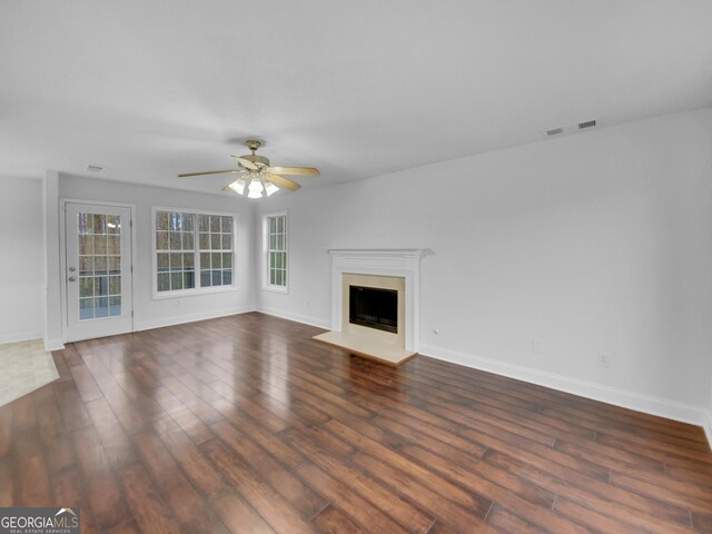 641 Morningside Dr, Stockbridge, GA 30281 - unfurnished living room with baseboards, visible vents, ceiling fan, dark wood-style flooring, and a fireplace