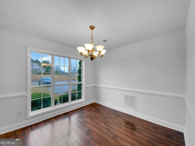 641 Morningside Dr, Stockbridge, GA 30281 - unfurnished dining area featuring a chandelier, dark wood-style flooring, a textured ceiling, and visible vents