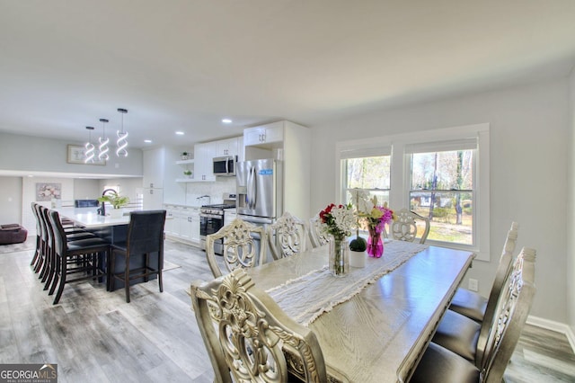 dining space with light wood-type flooring, baseboards, and recessed lighting