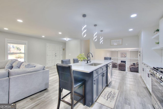 kitchen with stainless steel appliances, light countertops, a sink, and open floor plan