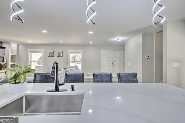 kitchen featuring open floor plan, a sink, and recessed lighting