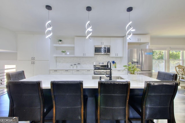 kitchen featuring appliances with stainless steel finishes, pendant lighting, white cabinetry, open shelves, and backsplash