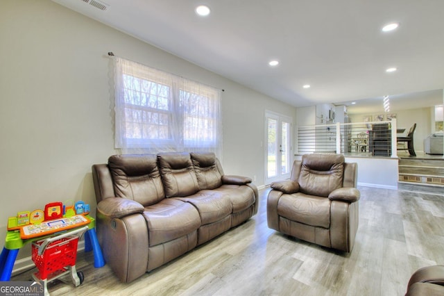 living area with recessed lighting, french doors, and light wood finished floors