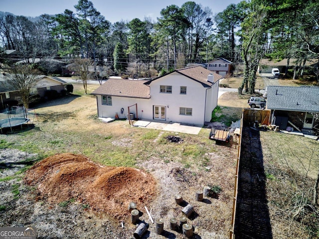 rear view of house featuring a patio area and a trampoline