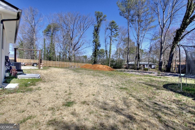 view of yard featuring a trampoline and fence private yard