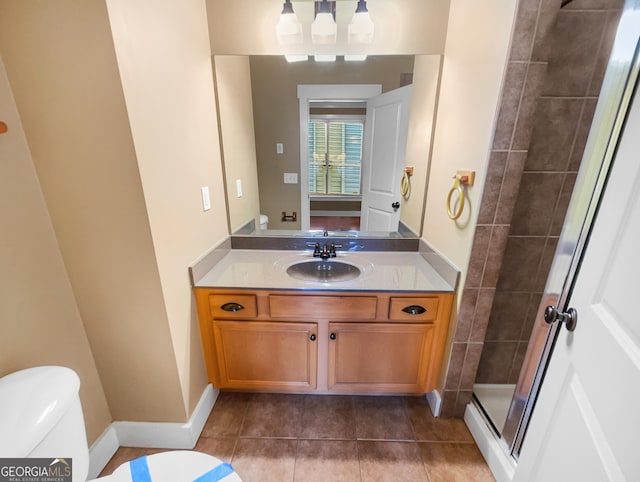 full bath with a stall shower, baseboards, toilet, tile patterned flooring, and vanity