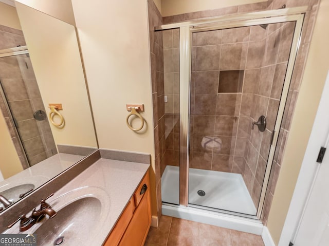 bathroom with a stall shower, vanity, and tile patterned floors