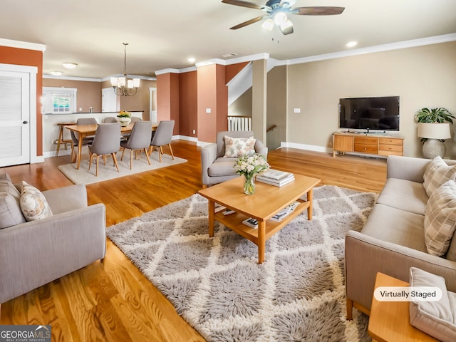 living room with baseboards, ceiling fan with notable chandelier, wood finished floors, and crown molding