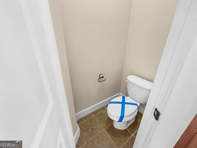 bathroom featuring tile patterned flooring, toilet, and baseboards