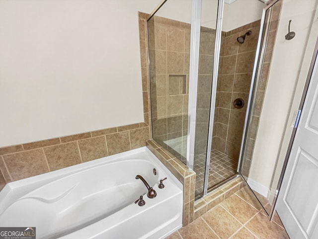 bathroom with a garden tub, a shower stall, and tile patterned floors