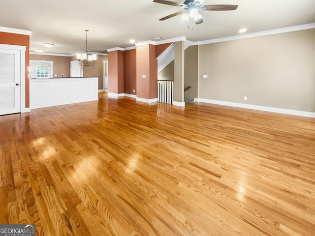 unfurnished living room with light wood-type flooring, baseboards, crown molding, and ceiling fan with notable chandelier