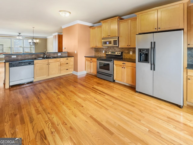 kitchen with tasteful backsplash, dark countertops, stainless steel appliances, light wood-style floors, and a sink