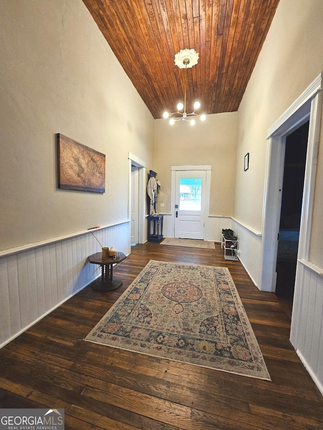 interior space featuring dark wood-style floors, wood ceiling, wainscoting, and an inviting chandelier