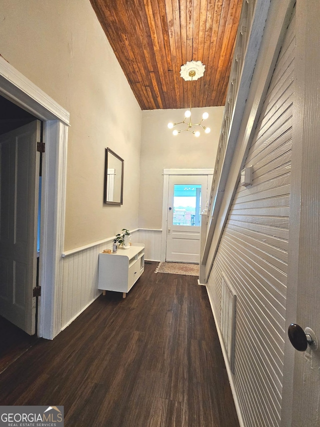 interior space featuring visible vents, wooden ceiling, a wainscoted wall, dark wood-type flooring, and a chandelier