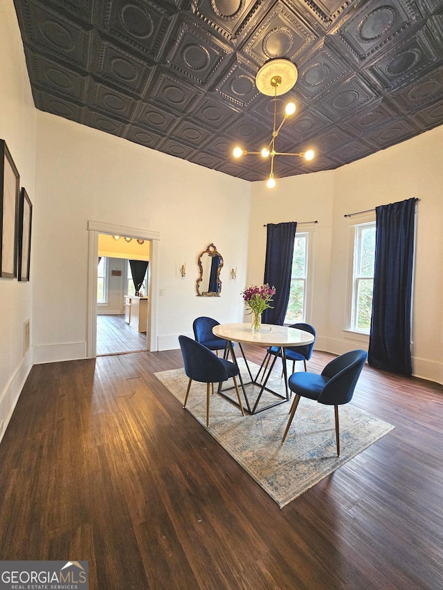 dining space with an ornate ceiling, baseboards, and wood finished floors