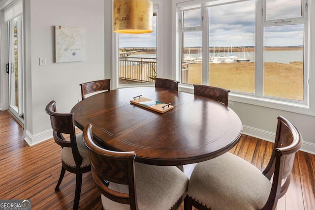 dining area with baseboards and wood finished floors