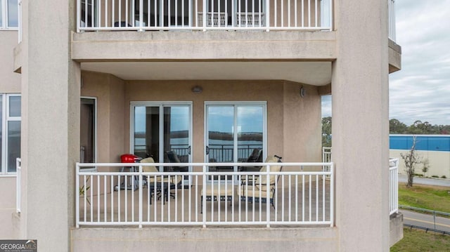 property entrance featuring a balcony and stucco siding