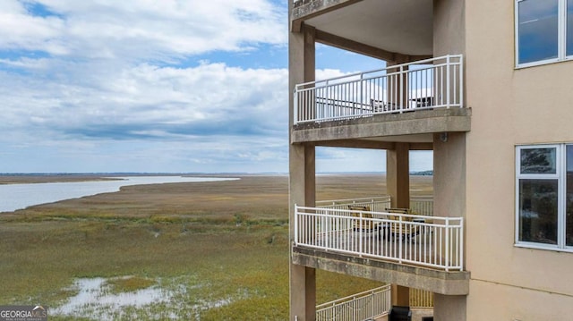 dock area with a water view and a balcony