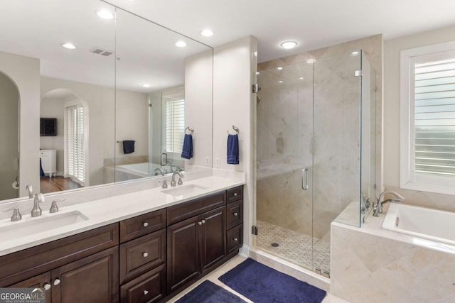 full bathroom featuring a sink, visible vents, a garden tub, and a shower stall