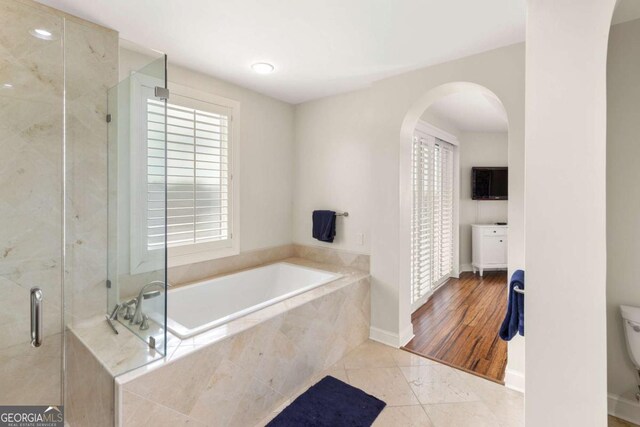 full bath with tile patterned floors, a garden tub, toilet, a stall shower, and baseboards