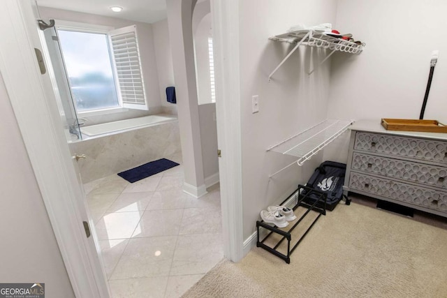 walk in closet featuring tile patterned floors and arched walkways