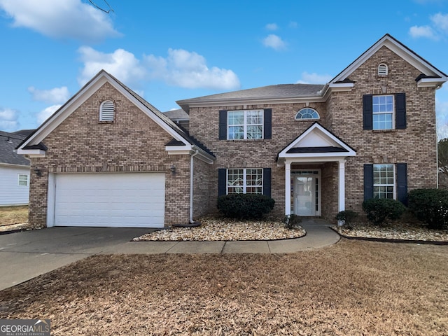 traditional home with an attached garage, concrete driveway, and brick siding