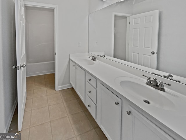 bathroom with double vanity, tile patterned flooring, baseboards, and a sink