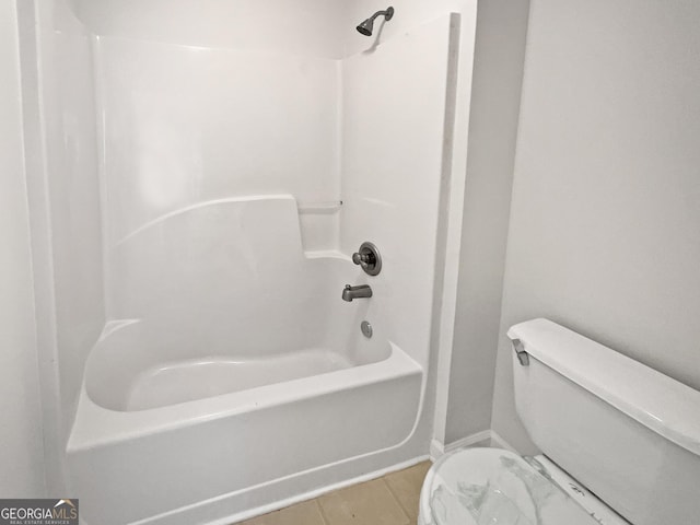 bathroom featuring toilet, tile patterned floors, and shower / bathing tub combination