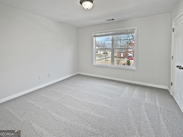 carpeted empty room with visible vents and baseboards