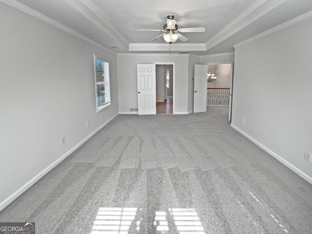 interior space featuring baseboards, ornamental molding, a raised ceiling, and carpet flooring